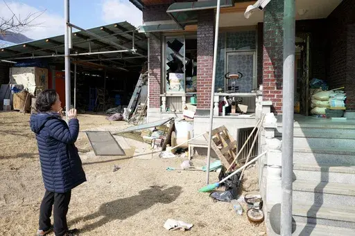 Local resident Park Sung-sook reacts at her damaged house near a bomb accident site in Pocheon, South Korea, Thursday, March 6, 2025. (AP Photo/Lee Jin-man)