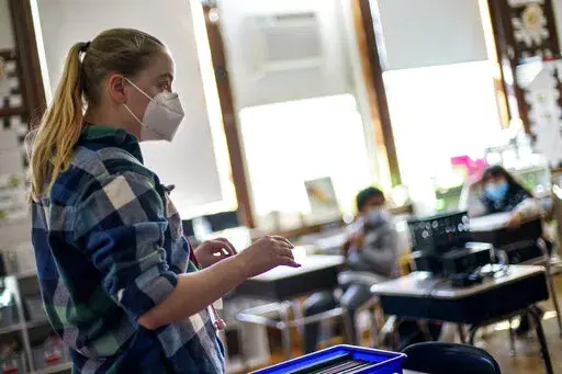 Music teacher Kristen Huetteman talks with fourth grade students at Raices Dual Language Academy, a public school in Central Falls, R.I., Wednesday, Feb. 9, 2022. (AP Photo/David Goldman)
