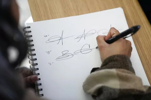 Priscilla Molina creates a custom signature in Los Angeles on Wednesday, Feb. 22, 2023. Molina designs a minimum of 300 custom signatures a month, offering packages that include up to three ways to sign, limitless drafts or a new set of initials. (AP Photo/Ashley Landis)