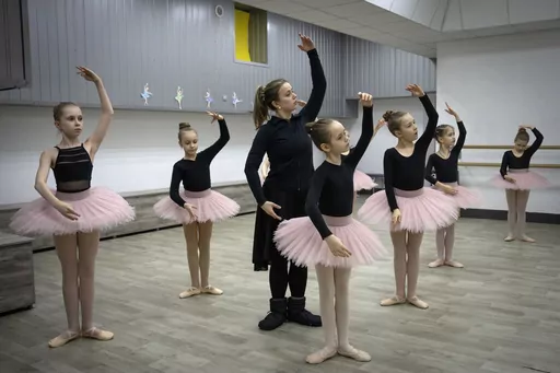 A ballet coach teaches girls in a ballet studio in a bomb shelter in Kharkiv, Ukraine, Monday, March 18, 2024. In northeast Ukraine, a dance studio that doubles as a bomb shelter is an escape from the horrors of war for about 20 young girls. The Princess Ballet Studio in Kharkiv is a spartan, windowless room, but practicing underground means they can dance through the almost hourly air raid alerts. (AP Photo/Efrem Lukatsky)