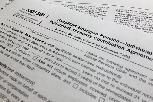 In this April 2, 2018, file photo, an IRS Form 5305, Simplified Employee Pension — Individual Retirement Accounts Contribution Agreement is shown in New York. Companies have long helped their workers save for retirement through 401(k)s and other workplace plans. But recent SECURE 2.0 legislation has blessed a newer trend: employers creating emergency savings options that could encourage workers to save more and avoid raiding their retirement funds. (AP Photo/Jenny Kane, File)