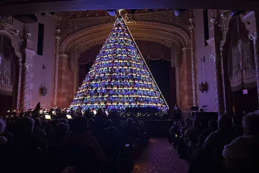 High school students sing while standing in a 67-foot-tall structure as part of the annual Mona Shores Singing Christmas Tree show Tuesday, Dec. 3, 2024, in Muskegon, Mich. (AP Photo/Mike Householder)