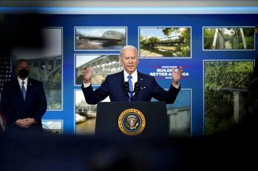 President Joe Biden speaks about the Bipartisan Infrastructure Law at the South Court Auditorium in the Eisenhower Executive Office Building on the White House Campus in Washington, Friday, Jan. 14, 2022, as Mitch Landrieu, Senior Advisor & Infrastructure Act Implementation Coordinator, looks on. (AP Photo/Andrew Harnik)