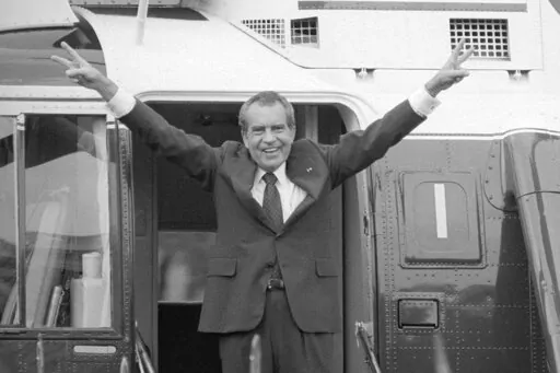 Richard Nixon says goodbye with a victorious salute to his staff members outside the White House as he boards a helicopter after resigning the presidency on Aug. 9, 1974. The traumas of Watergate and Jan. 6 are a half century apart, in vastly different eras, and they were about different things. But in both episodes, a president tried to do an end run around democracy. Friday is the 50th anniversary of the Watergate break-in that eventually consumed Richard Nixon's presidency.  (AP Photo/Bob Dau
