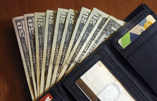 Cash is fanned out from a wallet in North Andover, Mass., June 15, 2018. Too many people cash out their 401(k)s when leaving a job — and part of the problem may be generous employer matches, researchers have found. Large matches can change how employees view their retirement savings, shifting their attitude from viewing a 401(k) as an “untouchable lockbox” to a liquid windfall of sorts. (AP Photo/Elise Amendola, File)