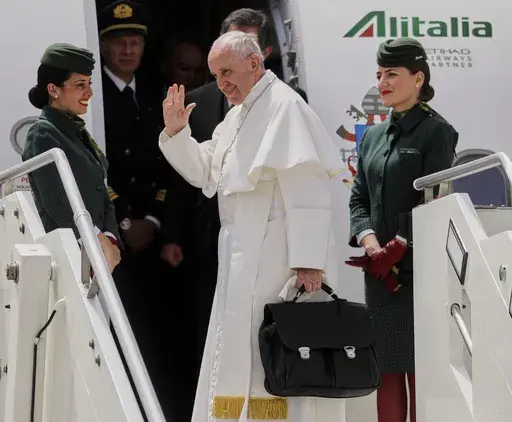 In this May 12, 2017 file photo, Pope Francis holds his bag and waves as he embarks his flight to Monte Real, Portugal, from Rome's International airport of Leonardo Da Vinci, in Fiumicino, Italy. (AP Photo/Gregorio Borgia, file)