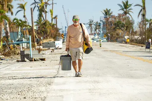 Gerry Arnold leaves Pine Island, Fla., after gathering a few belongings from his home after Hurricane Ian left behind widespread damage across the city on Tuesday, Oct. 4, 2022. (Scott Clause/The News-Press via AP)
