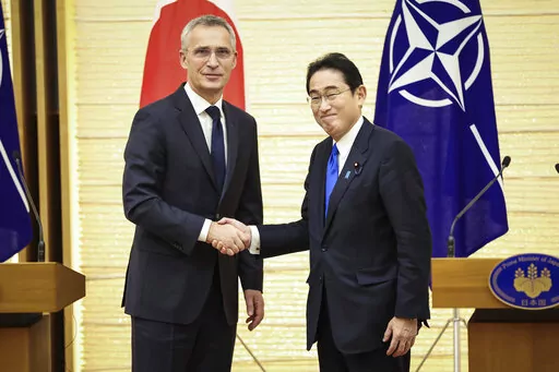 NATO Secretary-General Jens Stoltenberg, left, and Japan's Prime Minister Fumio Kishida shake hands after holding a joint media briefing on Tuesday, Jan. 31, 2023, in Tokyo. (Takashi Aoyama/Pool Photo via AP)