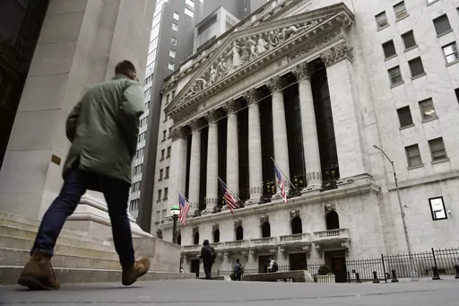FILE — People pass the front of the New York Stock Exchange, March 22, 2023. The average Wall Street bonus fell slightly last year to $176,500 as firms took a “more cautious approach” to compensation, New York state’s comptroller reported Tuesday, March 19, 2024. (AP Photo/Peter Morgan, File)
