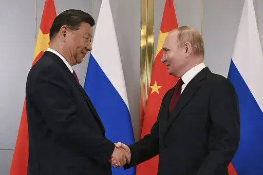 FILE -Russian President Vladimir Putin, right, and Chinese President Xi Jinping shake hands during their meeting on the sidelines of the Shanghai Cooperation Organisation (SCO) summit in Astana, Kazakhstan, July 3, 2024. China has accused NATO of seeking security at the expense of others and told the alliance not to bring the same “chaos” to Asia. The statement from a Foreign Ministry spokesperson on Thursday came a day after NATO labeled China a “decisive enabler” of Russia’s war agai
