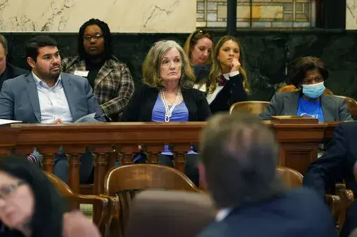 Mississippi Association of Educators executive director Antonio Castanon Luna, left, MAE consultant Pam Johnson, center and Geraldine Bender, Mississippi state president of the American Federation of Teachers, right, monitor a Senate Education Committee meeting at the Mississippi Capitol in Jackson, Tuesday, March 1, 2022. (AP Photo/Rogelio V. Solis)