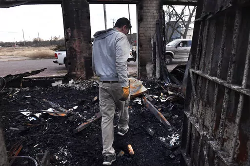 Jared Calvert exits the former Ranger Law Enforcement Center in Ranger, Texas Friday March 18, 2022.  Fire crews in West Texas hope to make progress Saturday against a massive complex of wildfires that have killed one person and burned at least 50 homes, officials said. (Ronald W. Erdrich/The Abilene Reporter-News via AP)