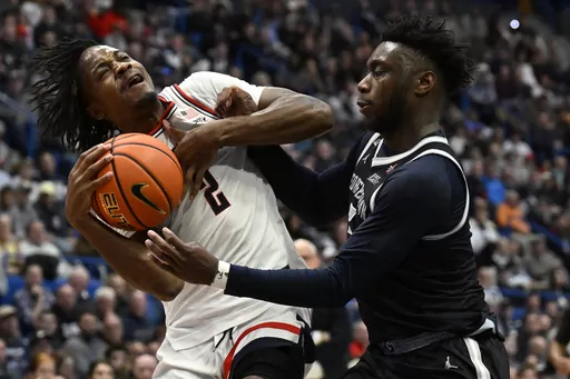 UConn guard Tristen Newton, left, is fouled by Georgetown guard Jay Heath in the second half of an NCAA college basketball game, Sunday, Jan. 14, 2024, in Hartford, Conn. (AP Photo/Jessica Hill)