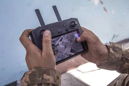 A Ukrainian soldier looks at a drone screen showing Russian troops positions during heavy fighting at the front line in Severodonetsk, Luhansk region, Ukraine, Wednesday, June 8, 2022. (AP Photo/Oleksandr Ratushniak)