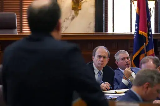 Lt. Gov. Delbert Hosemann, center, and House Speaker Philip Gunn, R-Clinton, listen as State Economist Corey Miller speaks about the state's economic outlook, during a meeting of the Joint Legislative Budget Committee, Friday, March 25, 2022, at the Mississippi Capitol in Jackson, Miss. (AP Photo/Rogelio V. Solis)