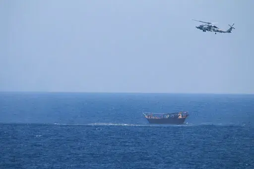A U.S. Navy Seahawk helicopter flies over a stateless dhow later found to be carrying a hidden arms shipment in the Arabian Sea, May 6, 2021. The U.S. Navy's Mideast-based 5th Fleet will begin Tuesday, July 5, 2022, to offer rewards for information that could help sailors intercept weapons, drugs and other illicit shipments across the region. The program launches against the backdrop of tensions over Iran’s nuclear program and Tehran’s arming of Yemen’s Houthi rebels. (U.S. Navy via AP, Fi