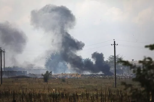 Smoke rises over the site of explosion at an ammunition storage of Russian army near the village of Mayskoye, Crimea, Tuesday, Aug. 16, 2022. Explosions and fires ripped through an ammunition depot in Russian-occupied Crimea on Tuesday in the second suspected Ukrainian attack on the peninsula in just over a week, forcing the evacuation of more than 3,000 people. (AP Photo)