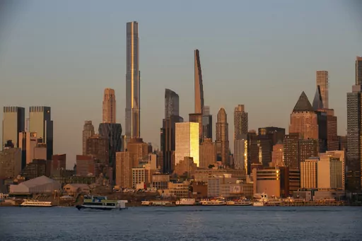 Light from the setting sun reflects off the buildings in the borough of Manhattan in New York City, as seen from the Weehawken Pier in Weehawken, N.J., on Wednesday, March 22, 2023. Living in a high-cost city can strain your finances, but three tips can help you thrive. Consider shopping at wholesale stores for groceries, even if you don’t have a car. Take advantage of discounts that cultural institutions such as museums and theaters often offer to residents through a city ID or library card. 