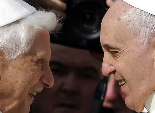 Pope Francis, right, greets Pope Emeritus Benedict XVI prior to the start of a meeting with elderly faithful in St. Peter's Square at the Vatican, on Sept. 28, 2014. Emeritus Pope Benedict XVI turned 95 this past weekend, a significant milestone on its own but even more given he has now been a retired pope longer than he was a reigning one.  To mark the occasion, a new book published Thursday, April 21, 2022 sets out to examine the current state of Vatican affairs not so much through the lens of