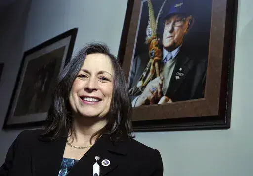 Marilynn "Lynn" Malerba stands next to a photograph of late Chief Ralph Sturges at Tribal offices in Uncasville, Conn., on March 4, 2010. Malerba, who is Native American, was nominated to be U.S. Treasurer in a historic first, Tuesday, June 21, 2022. Biden's nomination of Malerba to the federal Treasury role was announced ahead of Treasury Secretary Janet Yellen’s visit to the Rosebud Indian Reservation in South Dakota, Tuesday.  (AP Photo/Jessica Hill, File)