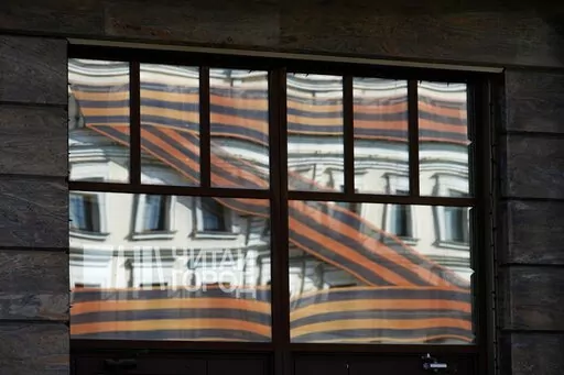 A huge letter Z, which has become a symbol of the Russian military, is reflected in an office building in a street in Moscow, Russia, Friday, May 6, 2022. Red Soviet flags and orange-and-black striped military ribbons are on display in Russian cities and towns. Neighborhoods are staging holiday concerts. Flowers are being laid by veterans' groups at monuments to the Great Patriotic War, as World War II is known in the country. At first glance, preparations for Monday's celebration of Victory Day