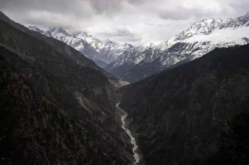 The Sutlej River flows in the valley below the tall snowy peaks in the Kinnaur district of the Himalayan state of Himachal Pradesh, India, March 13, 2023. A new report Tuesday, June 20, from a Nepal-based research organization finds that water security for nearly 2 billion people living downstream of rivers that originate in the Himalayan ranges will likely be threatened by the end of this century due to rapid glacier melt if global warming is not controlled. (AP Photo/Ashwini Bhatia, File)