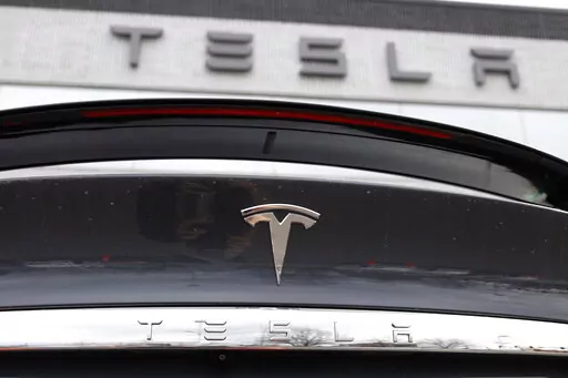 In this April 26, 2020 photo, the company logo shines off the rear deck of an unsold 2020 Model X at a Tesla dealership in Littleton, Colo. Tesla’s sales from April through June 2022 fell to their lowest quarterly level since last fall as supply chain issues and pandemic restrictions in China hobbled production of its electric vehicles. (AP Photo/David Zalubowski, File)