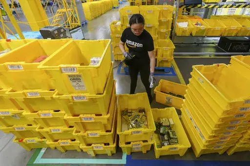 An employee scans incoming items at a receiving station at the Amazon OXR1 fulfillment center in Oxnard, Calif., on Aug. 21, 2024. (AP Photo/Damian Dovarganes, File)