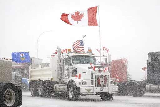 Anti-COVID-19 vaccine mandate demonstrators gather as a truck convoy blocks the highway at the busy U.S. border crossing in Coutts, Alberta, Canada, Monday, Jan. 31, 2022.  Thousands of antivaccine protesters descended on Canada’s capital of Ottawa in frigid temperatures to protest vaccine mandates, masks and restrictions over the weekend and some remain, blocking traffic around Parliament Hill in what has been the biggest pandemic protest in the country to date.(Jeff McIntosh/The Canadian Pre