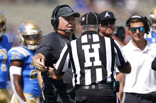 UCLA head coach Chip Kelly talks with an official during the first half of an NCAA college football game against Utah in Pasadena, Calif., Saturday, Oct. 8, 2022. (AP Photo/Ashley Landis)