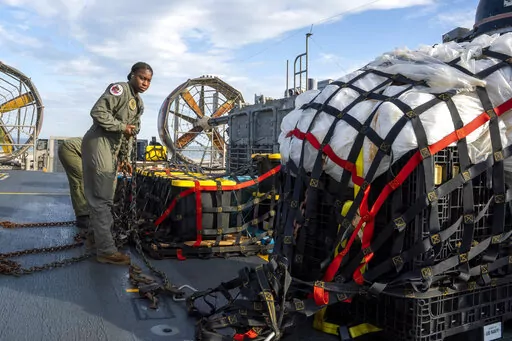In this image released by the U.S. Navy, sailors assigned to Assault Craft Unit 4 prepare material recovered off the coast of Myrtle Beach, S.C., in the Atlantic Ocean from the shooting down of a Chinese high-altitude balloon, for transport to the FBI, at Joint Expeditionary Base Little Creek in Virginia Beach, Va., on Feb. 10, 2023. The federal government's lack of information about four aerial objects recently shot down over North America is helping to fuel conspiracy theories and conjecture o