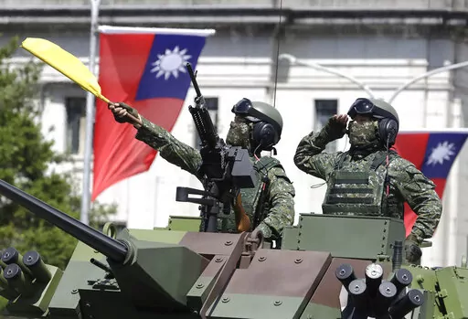 Taiwanese soldiers salute during National Day celebrations in front of the Presidential Building in Taipei, Taiwan on Oct. 10, 2021. As Russia presses ahead with its attack on Ukraine, many analysts and internet users have drawn comparisons to Taiwan, another place that could face an invasion by its larger neighbor, in this case China. (AP Photo/Chiang Ying-ying, File)