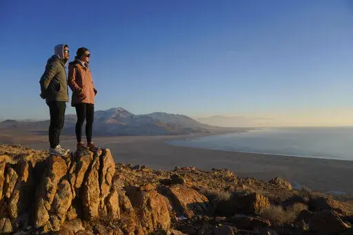 Antelope Island State Park visitors view the the receding edge of the Great Salt Lake Friday, Jan. 28, 2022, at Antelope Island, Utah. The largest natural lake west of the Mississippi is shrinking past its lowest levels in recorded history, raising fears about toxic dust, ecological collapse and economic consequences. But the Great Salt Lake may have some new allies: conservative Republican lawmakers. (AP Photo/Rick Bowmer)