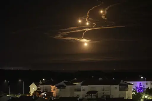 Flares rise over the Gaza Strip as seen from southern Israel, Monday, Jan. 8, 2024. (AP Photo/Leo Correa)