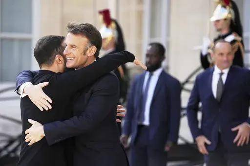 French President Emmanuel Macron, second left, greets Ukraine's President Volodymyr Zelenskyy during arrivals for a summit on Ukraine at the Elysee Palace in Paris, Thursday, March 27, 2025 . (AP Photo/Thibault Camus)