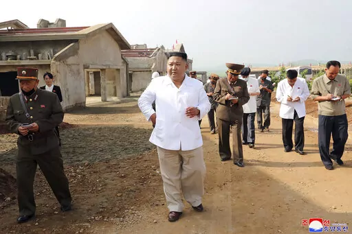 In this undated photo provided on July 23, 2020 by the North Korean government, North Korean leader Kim Jong Un, center, visits a new chicken farm being built in Hwangju County, North Korea. Independent journalists were not given access to cover the event depicted in this image distributed by the North Korean government. The content of this image is as provided and cannot be independently verified. Korean language watermark on image as provided by source reads: "KCNA" which is the abbreviation f