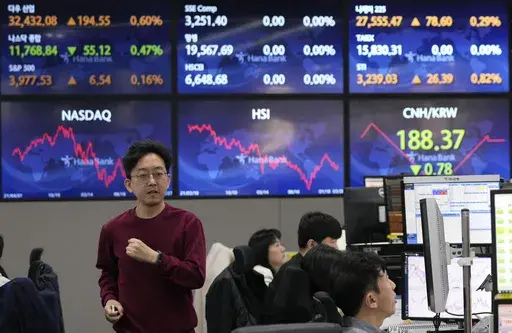 A currency trader passes by the screens showing the foreign exchange rates at the foreign exchange dealing room of the KEB Hana Bank headquarters in Seoul, South Korea, Tuesday, March 28, 2023. Asian shares were mostly higher on Tuesday as investors got some relief from worries over troubled U.S. banks with a planned takeover of failed Silicon Valley Bank.(AP Photo/Ahn Young-joon)