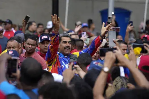 Venezuelan President Nicolas Maduro greets young supporters marching against U.S. sanctions, in Caracas, Venezuela, May 17, 2024. As Maduro seeks a third term, he has slowly transformed into a defender for migrants, challenging news reports linking some to criminal activities and accusing immigration authorities in other countries of abusing Venezuelans. (AP Photo/Ariana Cubillos, File)