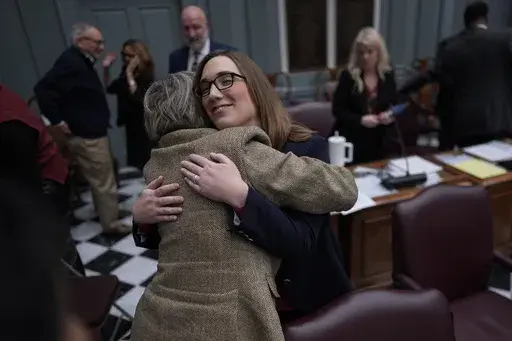 U.S.-Rep.-elect Sarah McBride, D-Del., hugs Delaware State Democrat Senator Laura Sturgeon from District 4 on the Senate floor during a special session, McBride's last day as a Delaware state senator, at the Delaware Legislative Hall in Dover, Del., Monday, Dec. 16, 2024. (AP Photo/Carolyn Kaster)