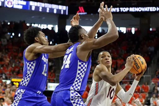 Auburn forward Jabari Smith (10) looks for an open shot as Kentucky forward Keion Brooks Jr. (12) and forward Oscar Tshiebwe (34) defends during the second half of an NCAA college basketball game Saturday, Jan. 22, 2022, in Auburn, Ala. (AP Photo/Butch Dill)
