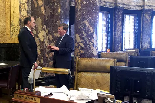 Lt. Gov. Delbert Hosemann, left, and Gov. Tate Reeves confer in an empty Senate chamber at the Mississippi State Capitol in Jackson, Miss., Tuesday, Feb. 1, 2022. (AP Photo/Emily Wagster Pettus)