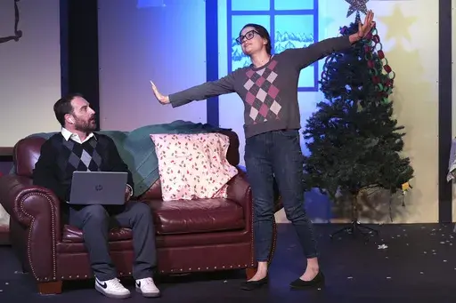 Josie Badley, right, and Justin Harris appear during a dress rehearsal for the production of "The Holiday Channel Christmas Movie Wonderthon" at the Ghostlight Theatre in Sun City West, Ariz., on Dec. 9, 2024. (AP Photo/Ross D. Franklin)