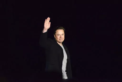 Elon Musk waves while providing an update on SpaceX's Starship, Thursday, Feb. 10, 2022, near Brownsville, Texas. In April 2022, a group of Tesla shareholders suing Musk over some 2018 tweets about taking the company private is asking a federal judge to order him to stop commenting on the case. (Miguel Roberts/The Brownsville Herald via AP, File)