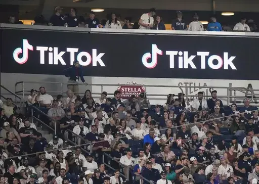 Fans sit under a TikTok ad at a baseball game at Yankee Stadium, April 14, 2023, in New York. A bill that could lead to the popular video-sharing app TikTok being unavailable in the United States is quickly gaining traction in the House. Lawmakers advanced legislation against TikTok Thursday as they voiced concerns about the potential for the platform to surveil and manipulate Americans. (AP Photo/Frank Franklin II, File)