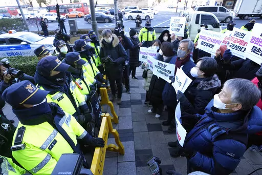 Protesters confront police officers during a rally to oppose Japan's adoption of a new national security strategy near the Japanese Embassy in Seoul, South Korea, Tuesday, Dec. 20, 2022. North Korea threatened Tuesday to take "bold and decisive military steps" against Japan as it slammed Tokyo's adoption of a national security strategy as an attempt to turn the country into an aggressive military power. The banners read "Stop military cooperation between South Korea, the U.S. and Japan military 