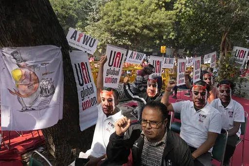 Participants wear paper masks in the likeness of Amazon's Jeff Bezos as warehouse workers and delivery drivers stage a protest against the Seattle-based company demanding higher wages and better working conditions, in New Delhi, India, Friday, Nov. 29, 2024. (AP Photo/Manish Swarup)