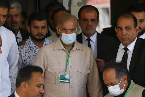 Pakistan's opposition leader Shahbaz Sharif, center, with his supporters leaves the Supreme Court after petitions hearing to dissolve parliament by country's Prime Minister, in Islamabad, Pakistan, Monday, April 4, 2022. Pakistan's top court began hearing arguments Monday on whether Prime Minister Imran Khan and his allies had the legal right to dissolve parliament and set the stage for early elections. (AP Photo/Anjum Naveed)