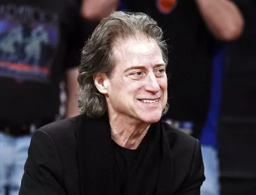 Comedian Richard Lewis attends an NBA basketball game in Los Angeles on Dec. 25, 2012. Lewis is retiring from stand-up following four surgeries and a diagnosis of Parkinson’s disease. The 75-year-old “Curb Your Enthusiasm” star who is known for wearing all-black and exploring his neuroses onstage posted a video Monday to Twitter explaining his various health issues. (AP Photo/Alex Gallardo, File)
