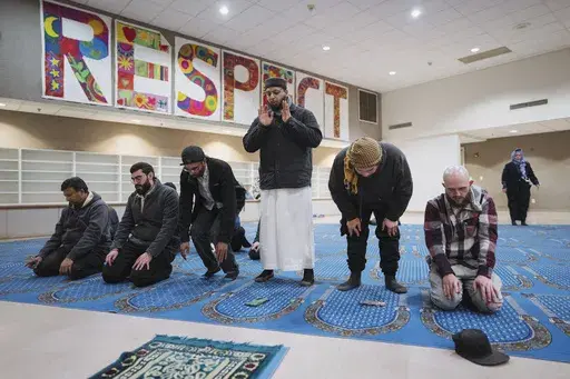 Junaid Aasi, center, a volunteer imam at Masjid Al-Taqwa, leads a prayer during a community gathering to discuss plans for Ramadan, held for members of the burned Altadena mosque, at a school in Pasadena, California, Saturday, Feb. 15, 2025. (AP Photo/Eric Thayer)