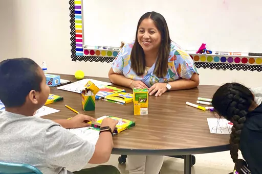 Lety Vargas, a newly hired English Language teacher at Russellville Elementary School, in Russellville, Ala., coaches small groups of students on her first day of school, Aug. 9, 2022. For years, rural Russellville's Central American population has grown, with immigrants moving to town to work at the local chicken processing plant. Now, some Spanish-speaking adults who graduated from that same school system are returning to teach students, hoping to give today's English learners a better experie